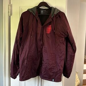 Girl skateboards windbreaker with hood.